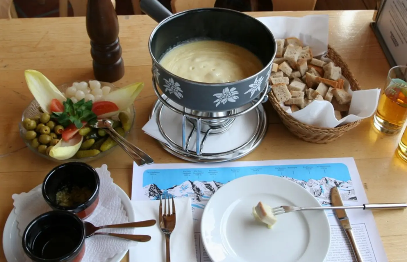 Service de fondue au fromage sur une table suisse, image Wikimedia Commons